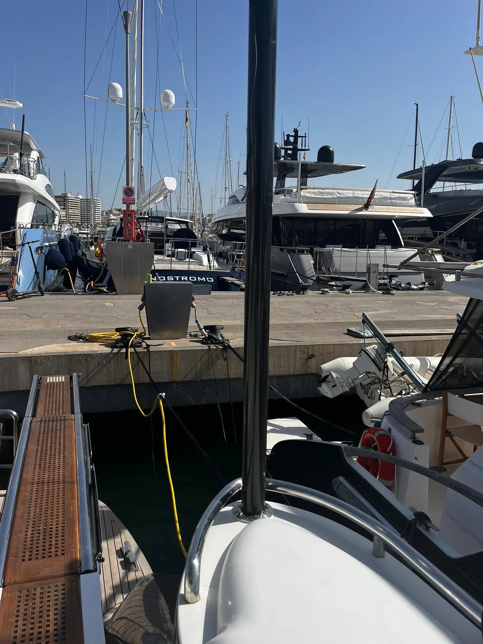 2004 Pershing 76 yacht docked at a marina with other luxury boats.