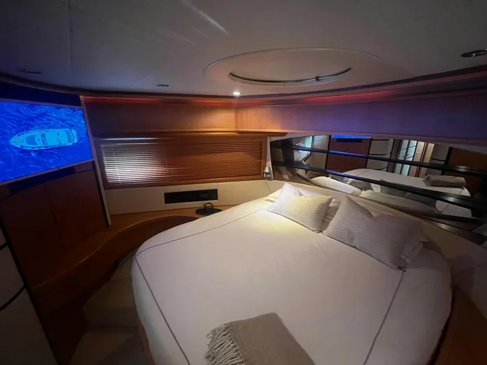  Yacht Photos Pics Luxurious bedroom interior of a 2004 Pershing 76 yacht with cozy bedding and ambient lighting.