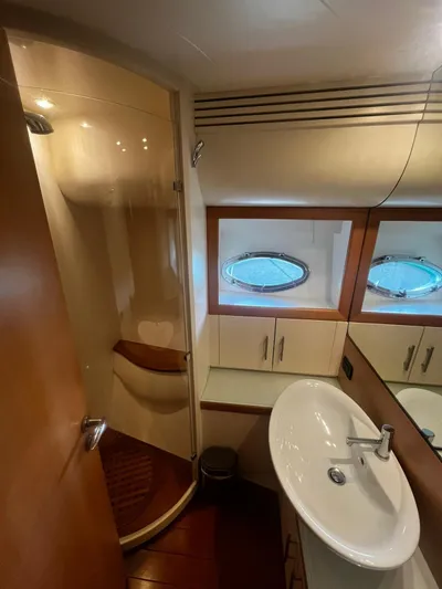  Yacht Photos Pics Luxurious bathroom in 2004 Pershing 76 yacht with modern fixtures and porthole windows.