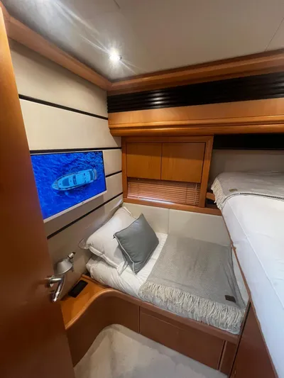 Yacht Photos Pics Luxurious cabin interior of a 2004 Pershing 76 yacht with cozy bedding and elegant wood finishes.