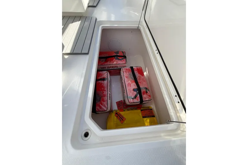  Yacht Photos Pics Storage compartment on 2022 Invincible 40 Catamaran with life jackets and safety equipment.