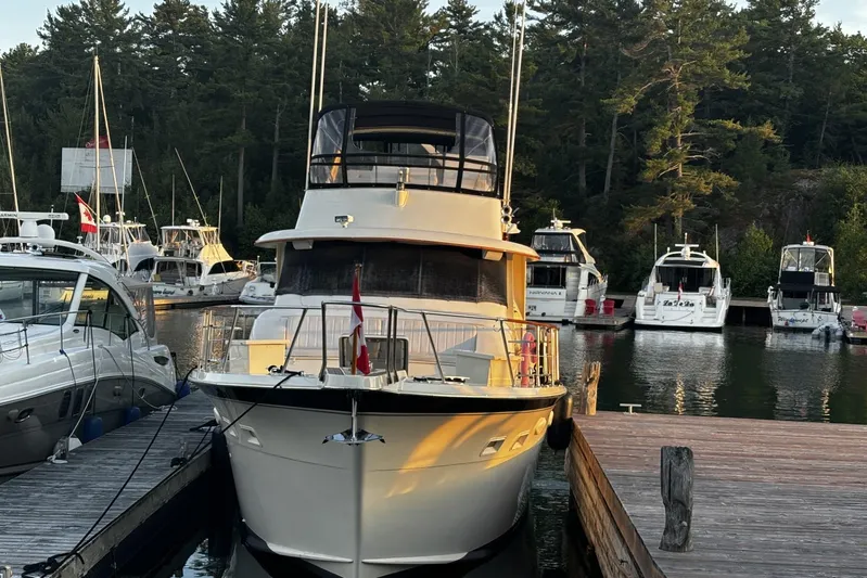  Yacht Photos Pics 1985 Hatteras 53 Extended Deckhouse Motor Yacht docked at marina, surrounded by trees.