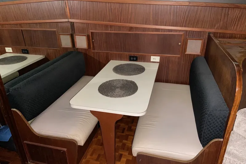  Yacht Photos Pics 1985 Hatteras 53 Motor Yacht dining area with wood paneling and cushioned seating.