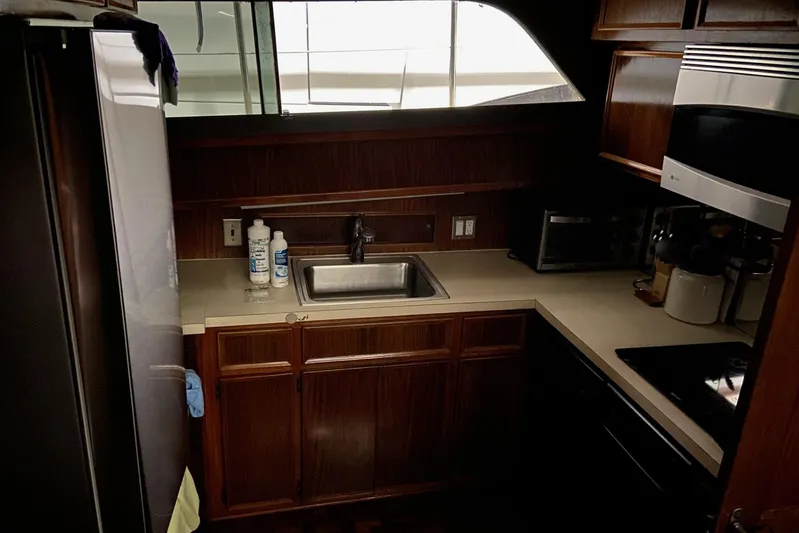  Yacht Photos Pics Compact kitchen in 1985 Hatteras 53 Extended Deckhouse Motor Yacht with wood cabinetry and modern appliances.