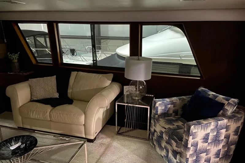  Yacht Photos Pics Interior of 1985 Hatteras 53 Motor Yacht with cozy seating and large windows.
