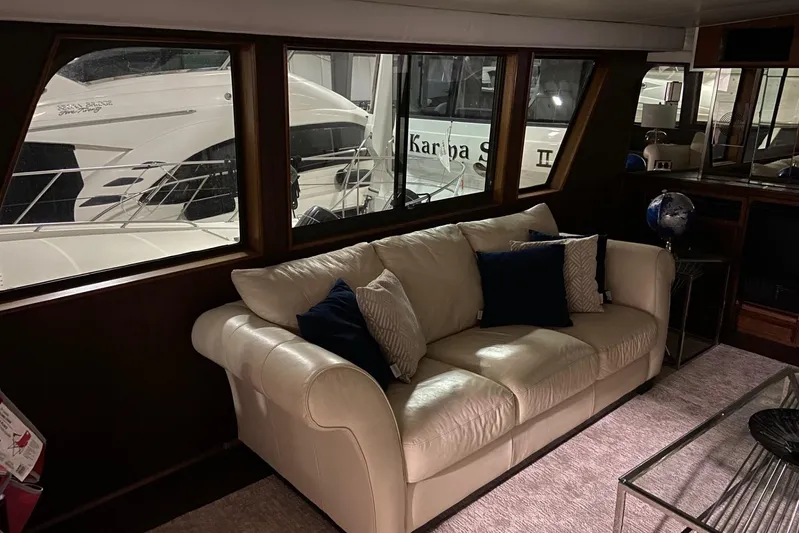  Yacht Photos Pics Interior of 1985 Hatteras 53 Motor Yacht with cream sofa and nautical decor.