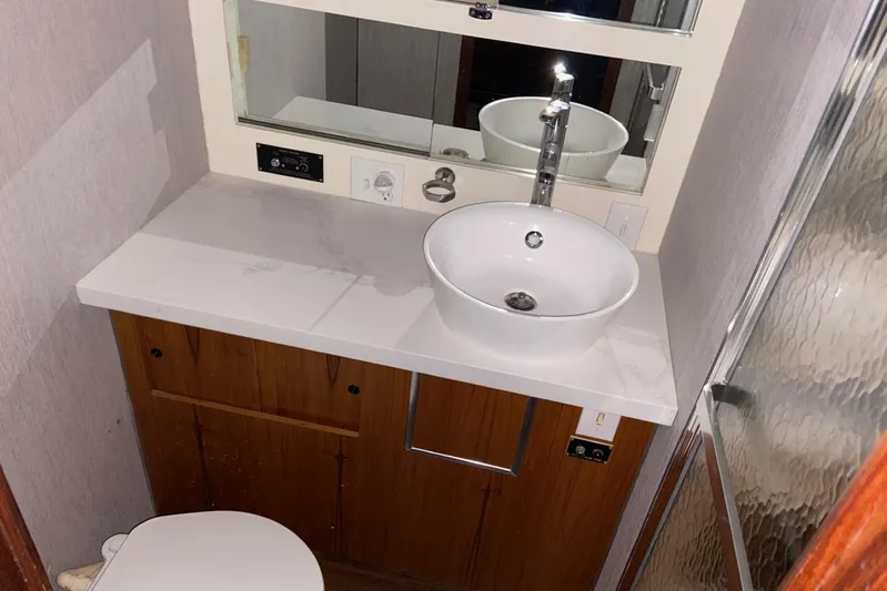  Yacht Photos Pics Bathroom interior of 1985 Hatteras 53 Motor Yacht with modern sink and mirror.