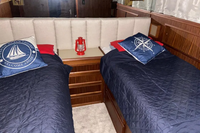  Yacht Photos Pics Cozy cabin interior of 1985 Hatteras 53 Motor Yacht with nautical-themed bedding.