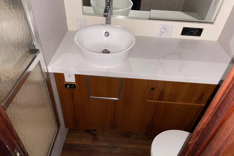  Yacht Photos Pics Bathroom interior of 1985 Hatteras 53 Extended Deckhouse Motor Yacht with modern sink and shower.