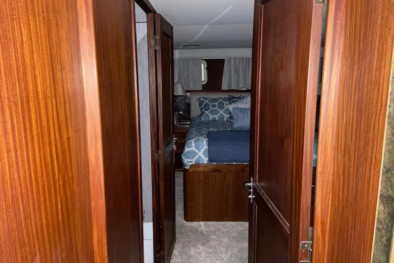  Yacht Photos Pics 1985 Hatteras 53 Motor Yacht cabin interior with wood paneling and cozy bedding.