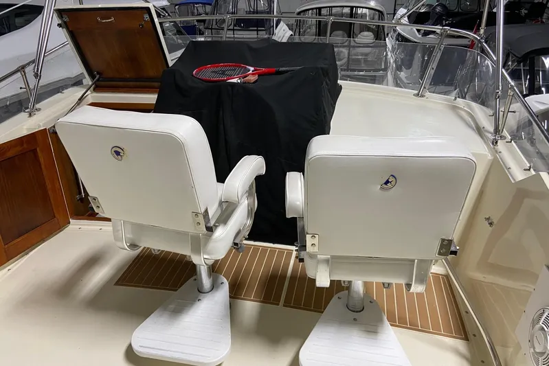  Yacht Photos Pics 1985 Hatteras 53 Motor Yacht deck with white chairs and tennis racket.