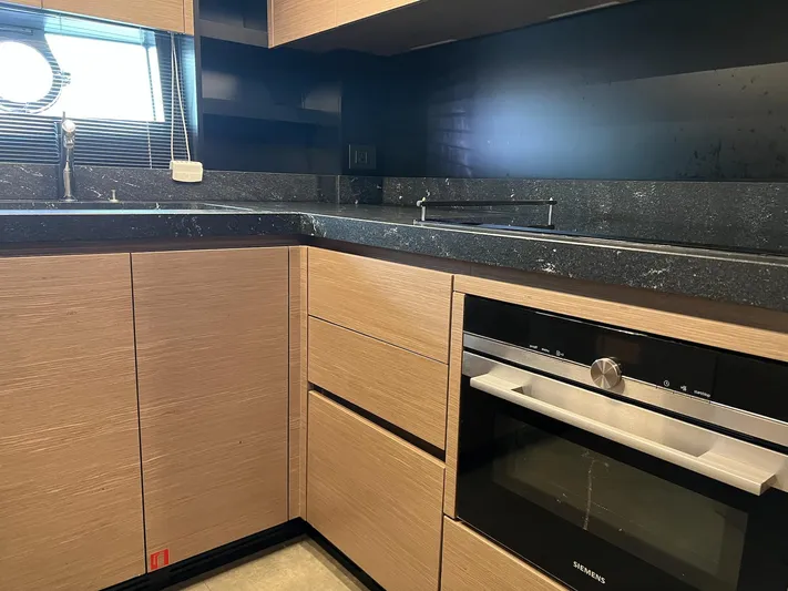  Yacht Photos Pics Modern kitchen in 2018 Ferretti Yachts 780 with sleek wood cabinetry and black countertops.