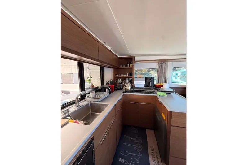  Yacht Photos Pics Modern kitchen interior of 2020 Lagoon 46 yacht with wooden cabinetry and stainless steel sink.