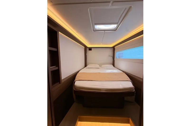  Yacht Photos Pics Luxurious cabin interior of 2020 Lagoon 46 yacht with cozy bed and ambient lighting.