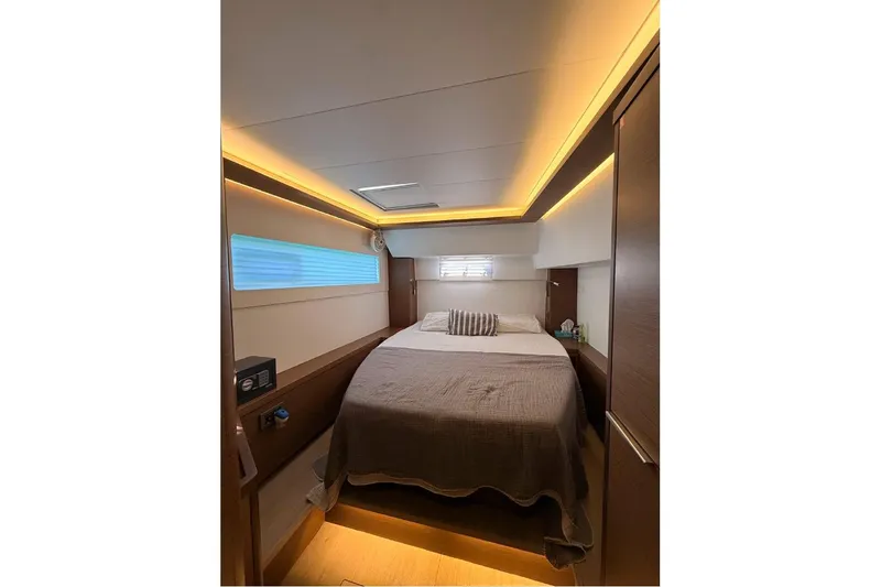  Yacht Photos Pics Luxurious cabin interior of 2020 Lagoon 46 yacht with ambient lighting and cozy bedding.