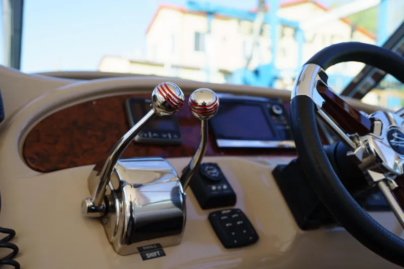  Yacht Photos Pics Control panel of a 2004 Sea Ray Sundancer 460 yacht with steering wheel and throttle levers.