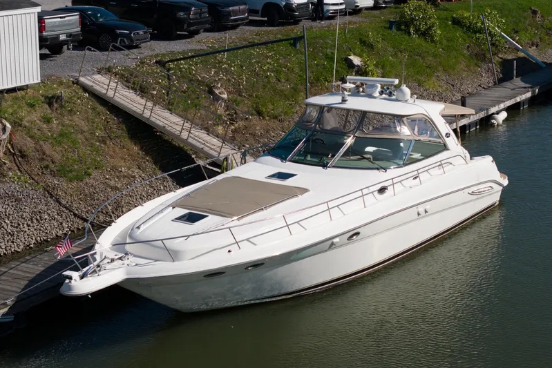  Yacht Photos Pics 2004 Sea Ray Sundancer 460 yacht docked in a marina, surrounded by greenery.