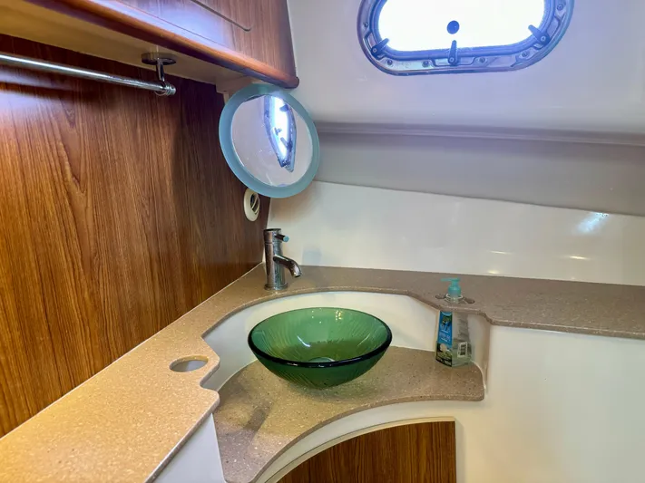  Yacht Photos Pics 2009 Pursuit OS 375 Offshore bathroom with glass sink and wooden cabinetry.