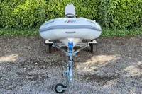 2021 AB Inflatables Lammina 10 AL boat on trailer, parked on gravel.