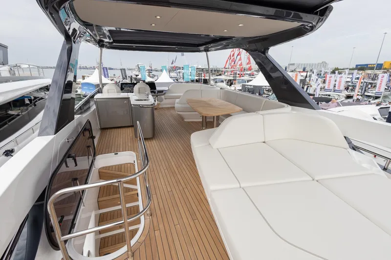  Yacht Photos Pics Luxurious 2024 Princess F65 yacht deck with seating and modern amenities at a marina.