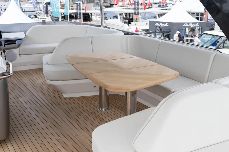  Yacht Photos Pics Luxurious seating area on 2024 Princess F65 yacht with wooden table and white cushions.