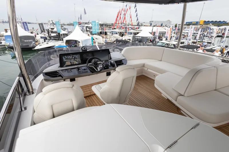  Yacht Photos Pics Luxurious 2024 Princess F65 yacht interior with modern helm and spacious seating at a boat show.