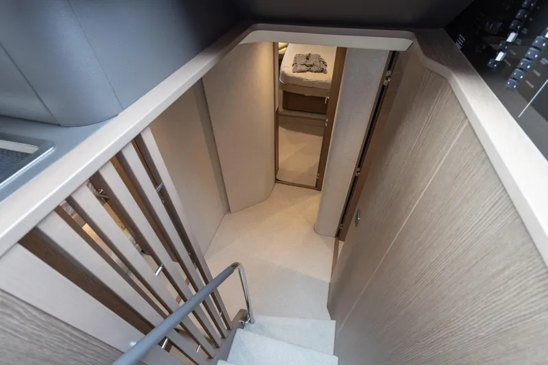 Yacht Photos Pics Interior staircase of 2024 Princess F65 yacht, featuring modern design and wood finishes.