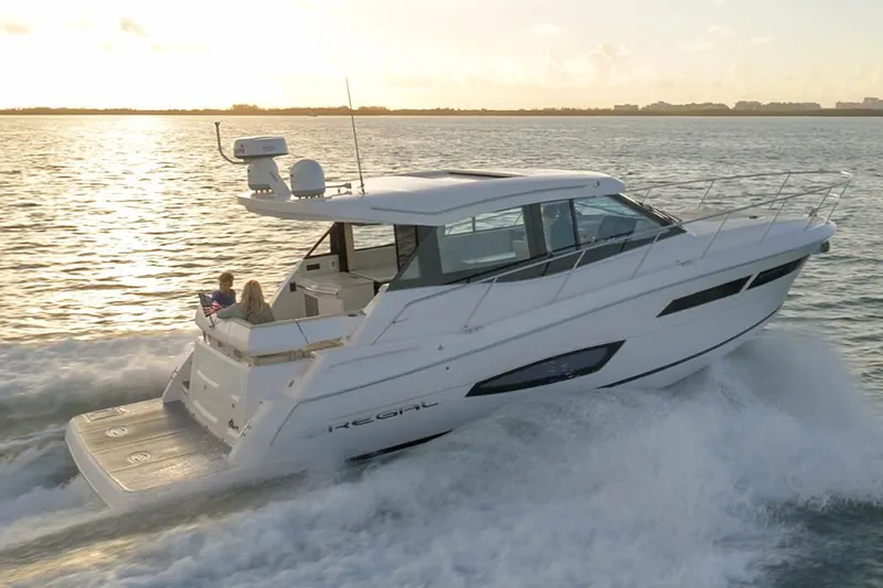  Yacht Photos Pics Manufacturer Provided Image: 2020 Regal 38 Grande Coupe cruising on open water at sunset.