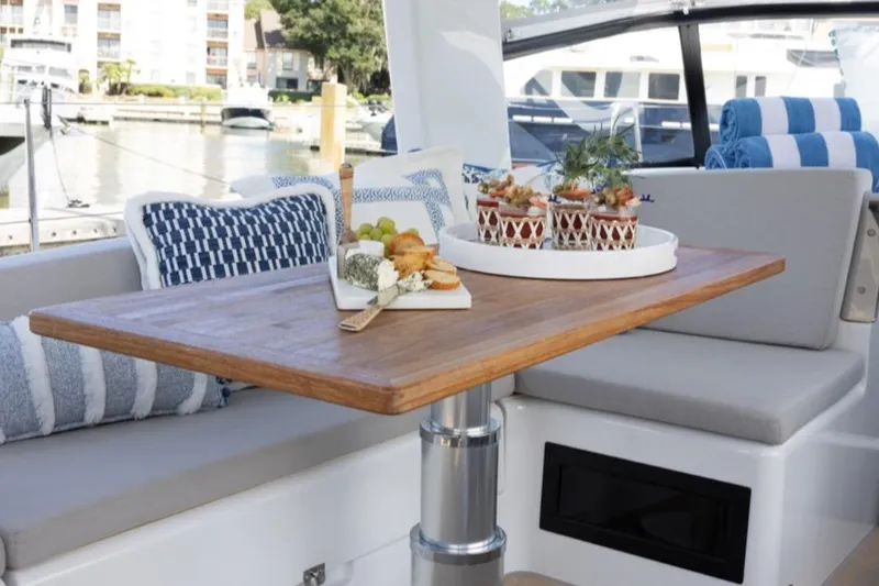 Navigamus Yacht Photos Pics 2023 Hanse 460 yacht interior with elegant dining setup on wooden table.