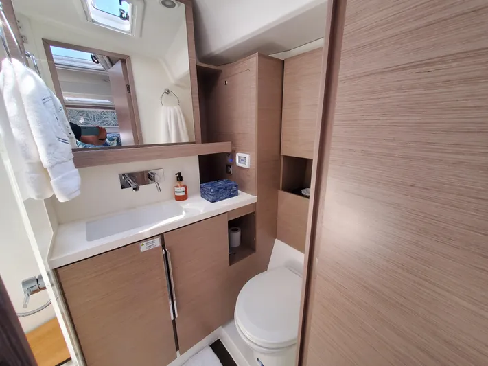 Navigamus Yacht Photos Pics Modern bathroom in 2023 Hanse 460 yacht with wood cabinetry and sleek fixtures.