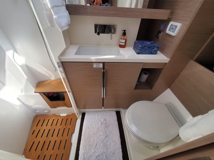Navigamus Yacht Photos Pics Modern bathroom in 2023 Hanse 460 yacht with sink, toilet, and wooden accents.