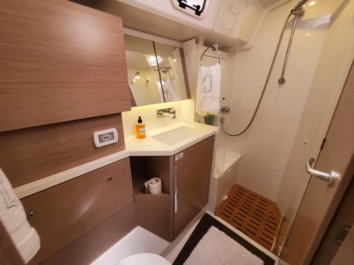Navigamus Yacht Photos Pics Modern bathroom in 2023 Hanse 460 yacht with wooden cabinetry and sleek shower design.
