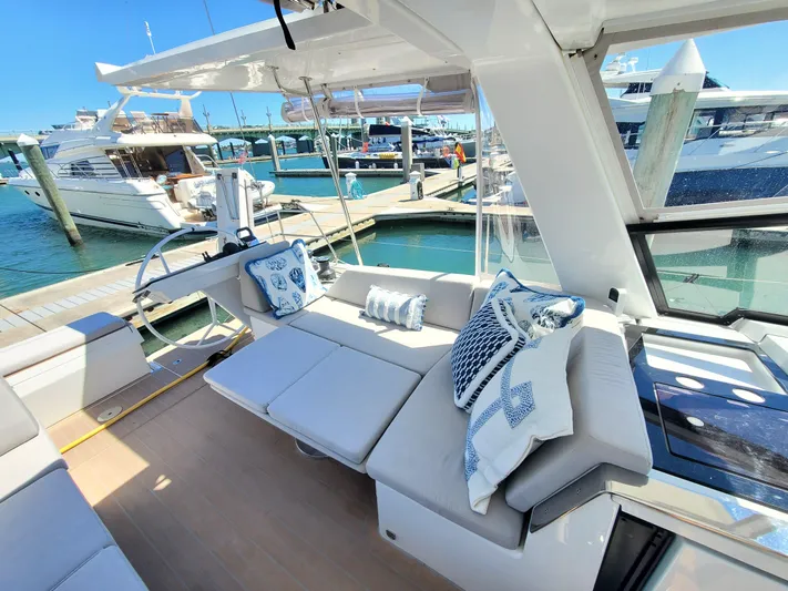 Navigamus Yacht Photos Pics Luxurious 2023 Hanse 460 yacht interior with plush seating and nautical-themed cushions at a marina.