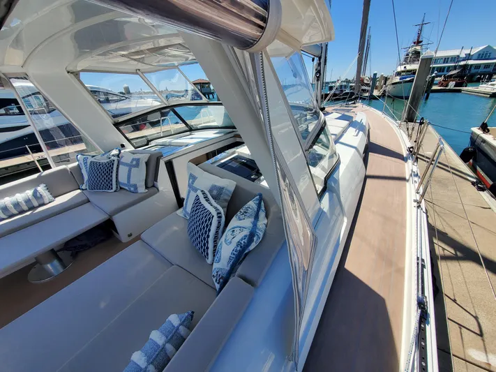 Navigamus Yacht Photos Pics Luxurious 2023 Hanse 460 yacht with elegant seating and nautical-themed cushions at a marina.