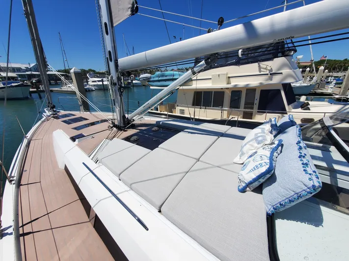 Navigamus Yacht Photos Pics 2023 Hanse 460 yacht deck with cushions, docked in a sunny marina.