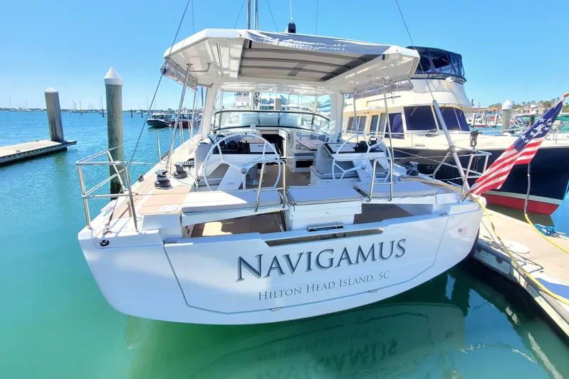 Navigamus Yacht Photos Pics 2023 Hanse 460 yacht docked at marina, featuring spacious deck and elegant design.