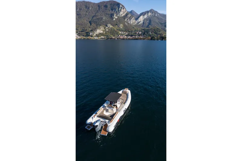  Yacht Photos Pics 2026 BWA GTO 308 boat cruising on a serene lake with mountainous backdrop.