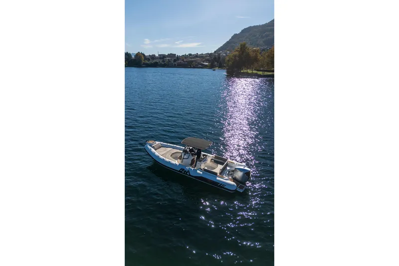  Yacht Photos Pics 2026 BWA GTO 308 boat on a serene lake with scenic mountain backdrop.