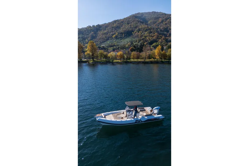  Yacht Photos Pics 2026 BWA GTO 308 boat cruising on a serene lake with scenic mountain backdrop.