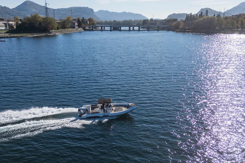  Yacht Photos Pics A BWA GTO 308 boat cruising on a scenic lake with mountains in the background.