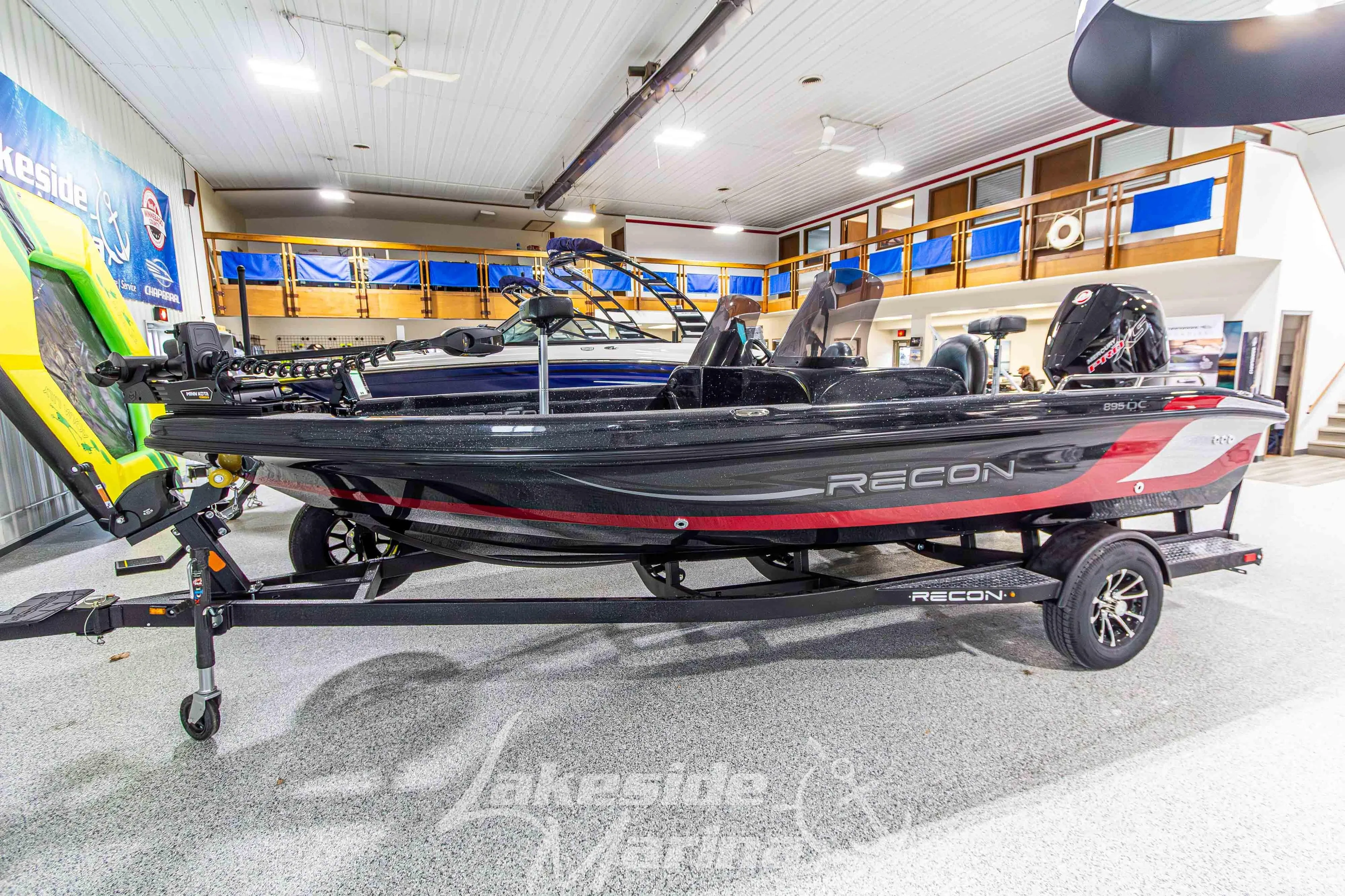 2026 Recon 895 DC boat on display in showroom, featuring sleek design and modern features.