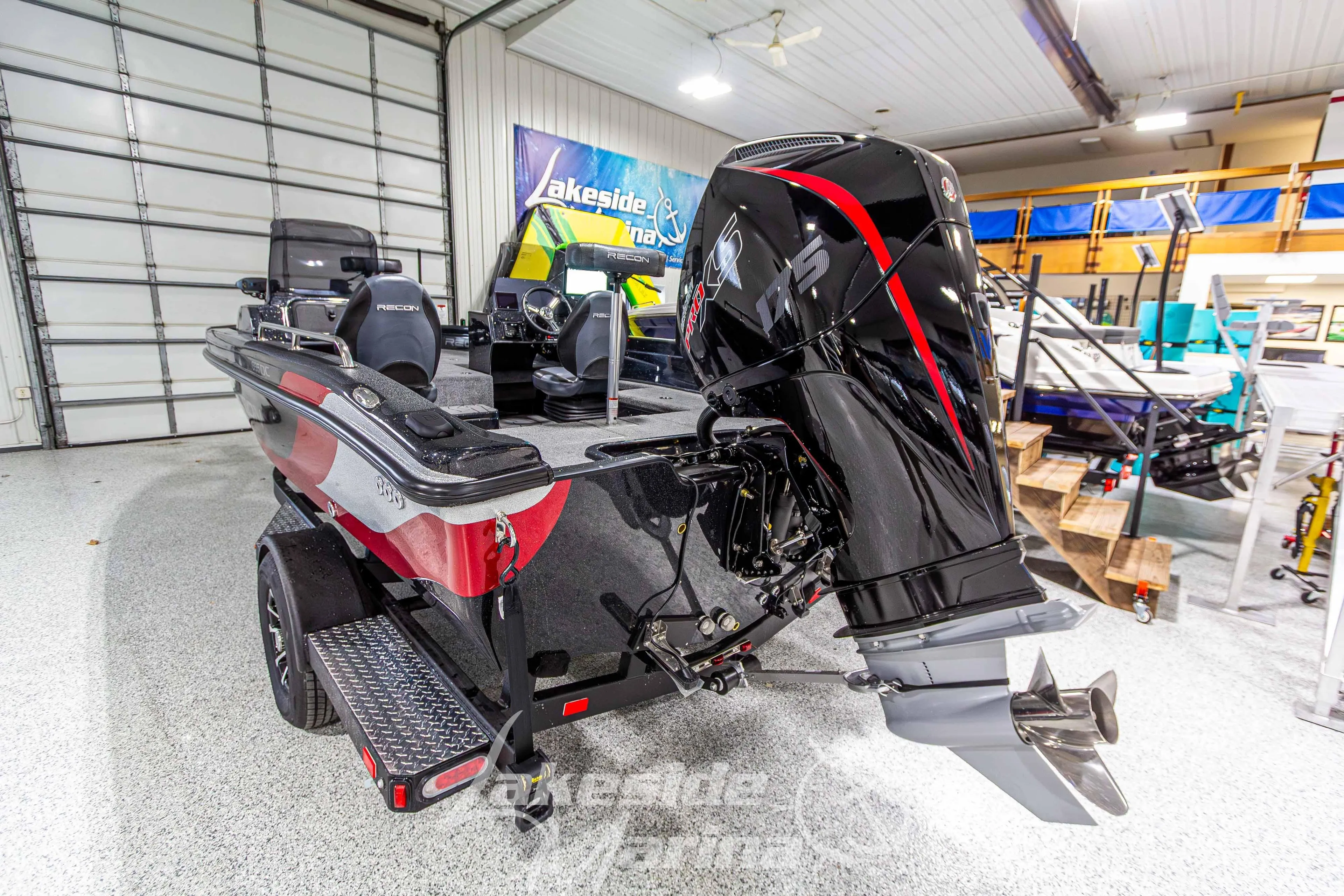 2026 Recon 895 DC boat with powerful outboard motor in showroom setting.