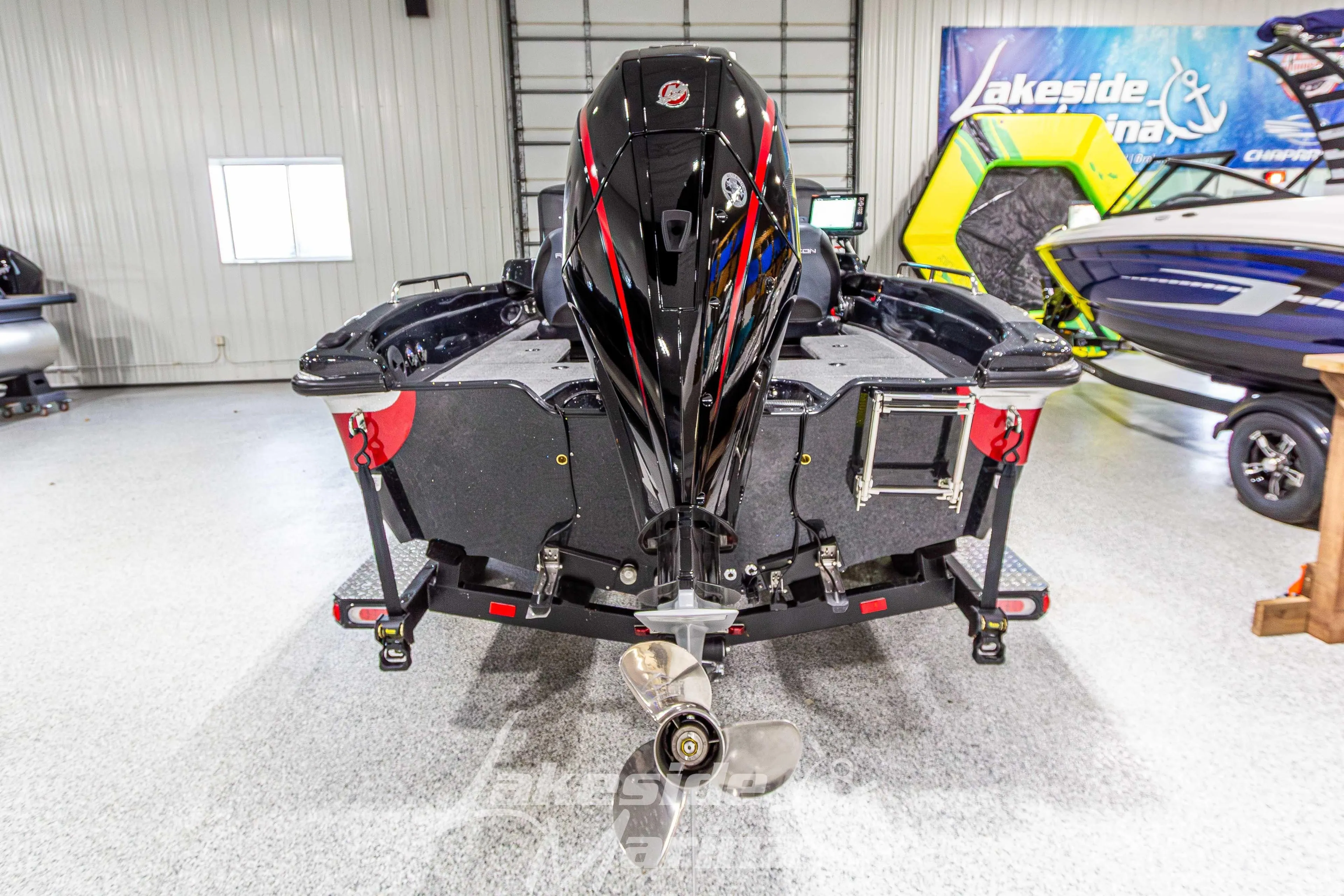 2026 Recon 895 DC boat in showroom, rear view with outboard motor.