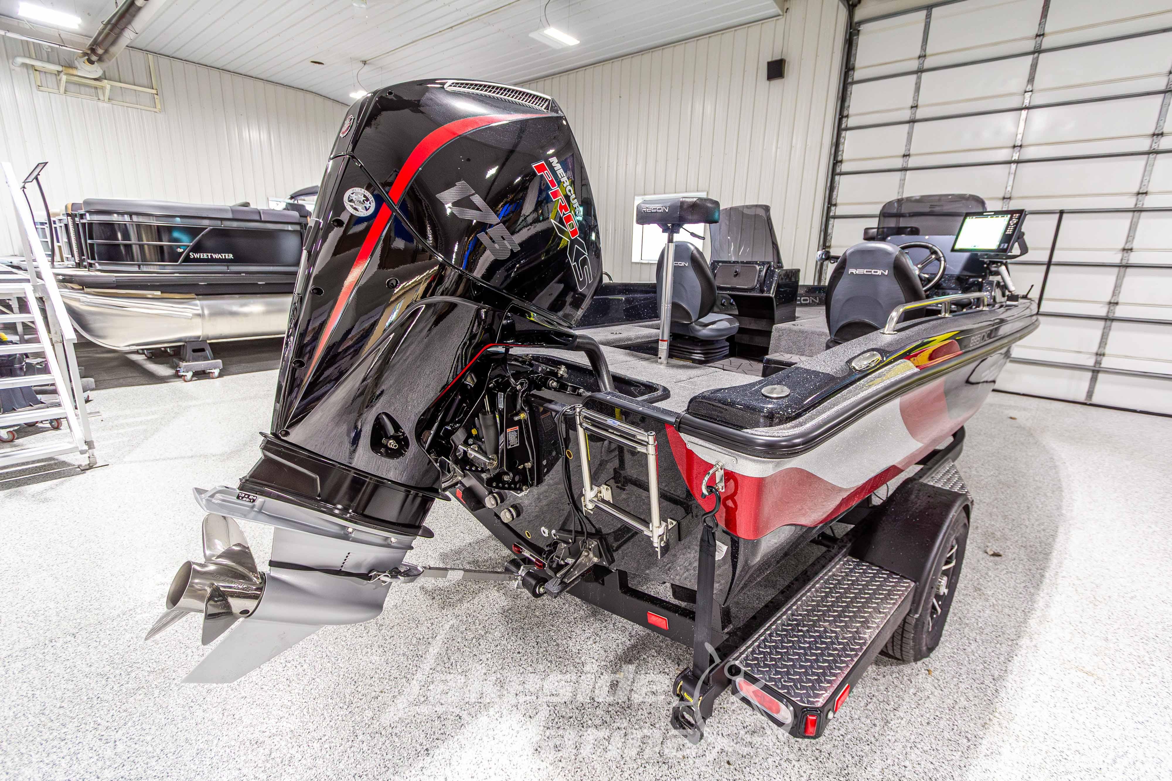 2026 Recon 895 DC boat with powerful outboard motor in a showroom setting.
