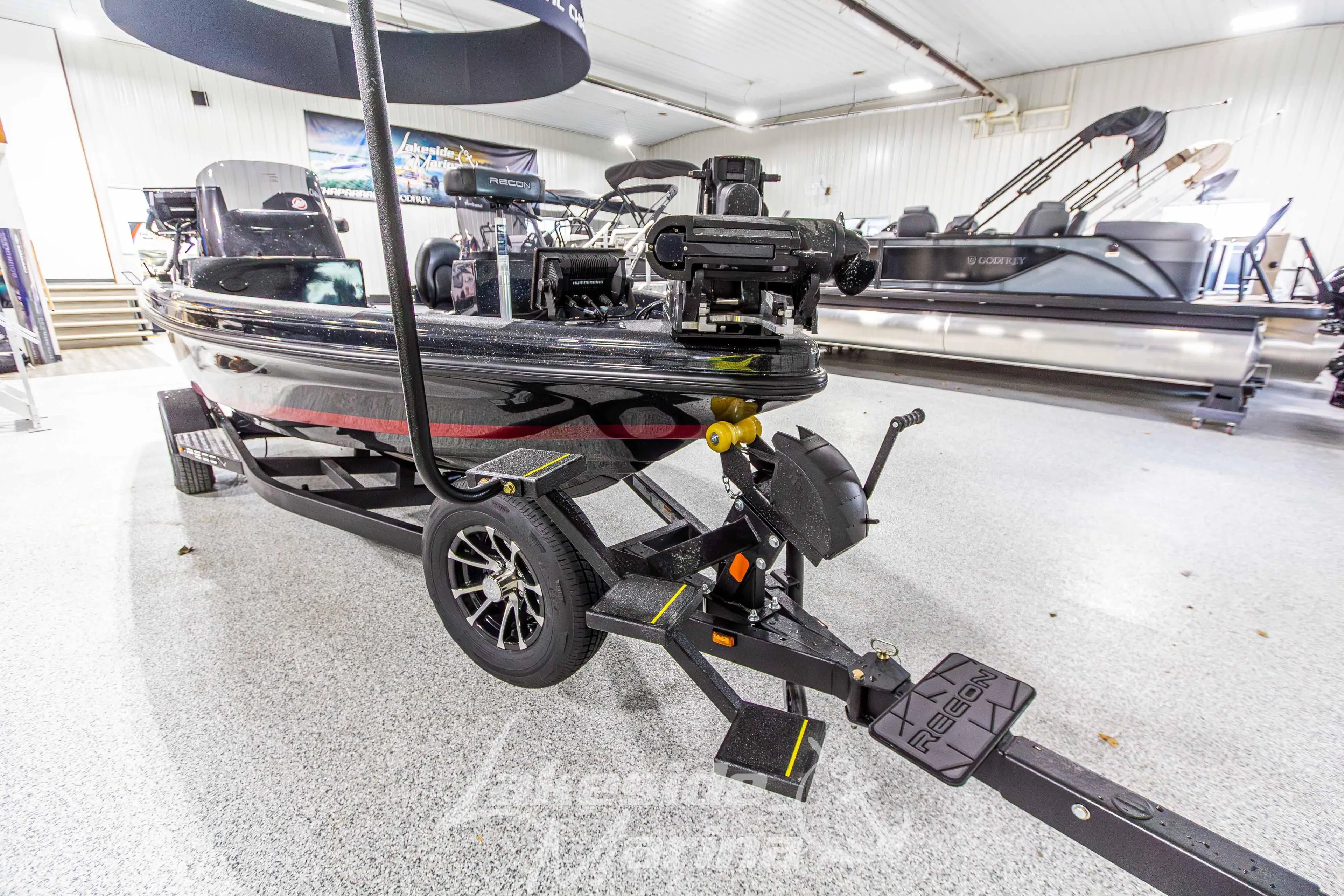 2026 Recon 895 DC boat on trailer in showroom, featuring sleek design and modern equipment.