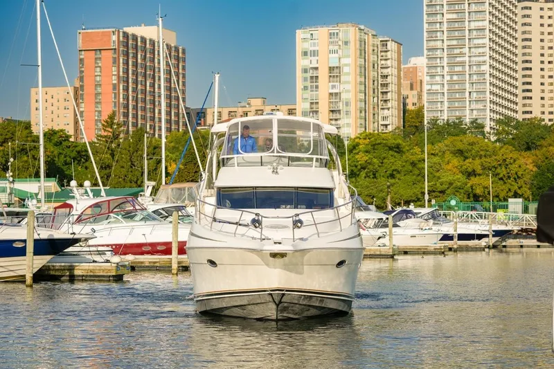  Yacht Photos Pics 2003 Silverton 410 Sport Bridge yacht docked in urban marina with city skyline.