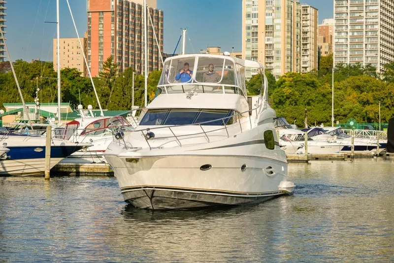  Yacht Photos Pics 2003 Silverton 410 Sport Bridge yacht docked in a marina with cityscape background.