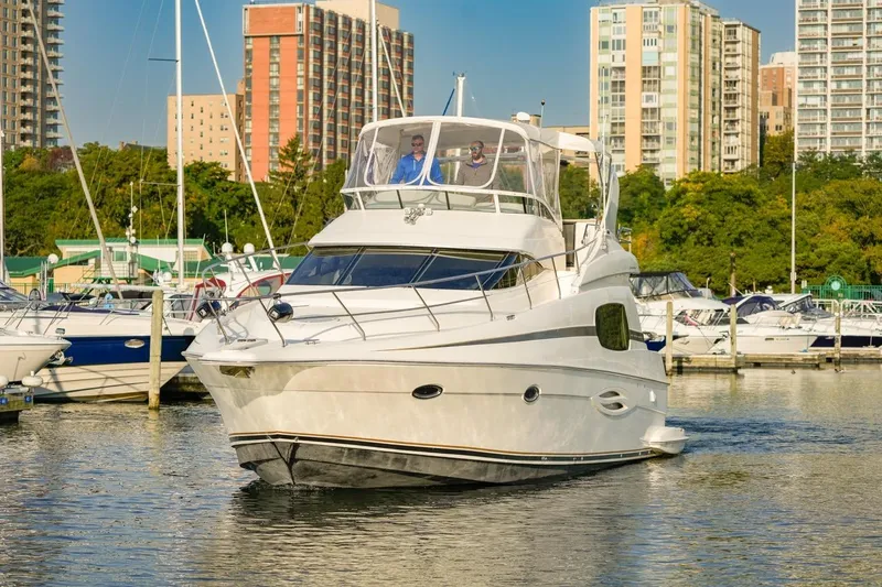  Yacht Photos Pics 2003 Silverton 410 Sport Bridge yacht docked in a marina with cityscape background.