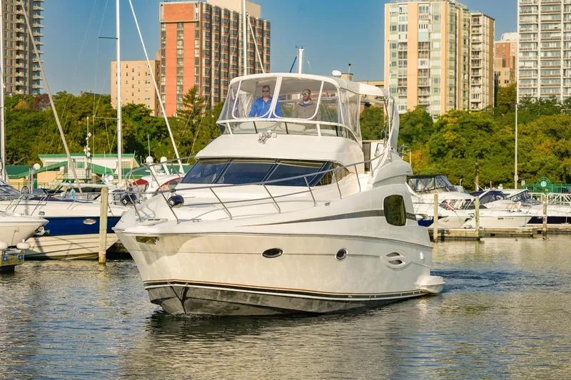  Yacht Photos Pics 2003 Silverton 410 Sport Bridge yacht docked in a marina with cityscape background.