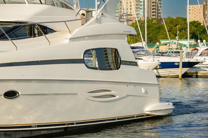  Yacht Photos Pics 2003 Silverton 410 Sport Bridge yacht docked in a marina with cityscape background.